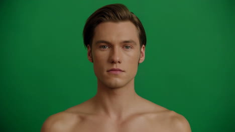 close-up portrait of a shirtless young man against a green screen