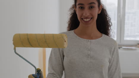 happy young woman painting a room