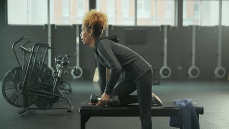 woman working out with dumbbells in gym