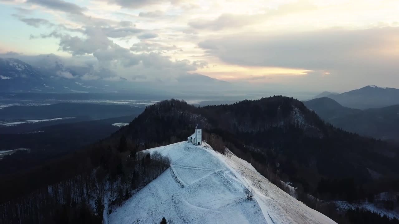 vista de la iglesia jamnik en un paisaje invernal con un colorido amanecer en kranj, eslovenia