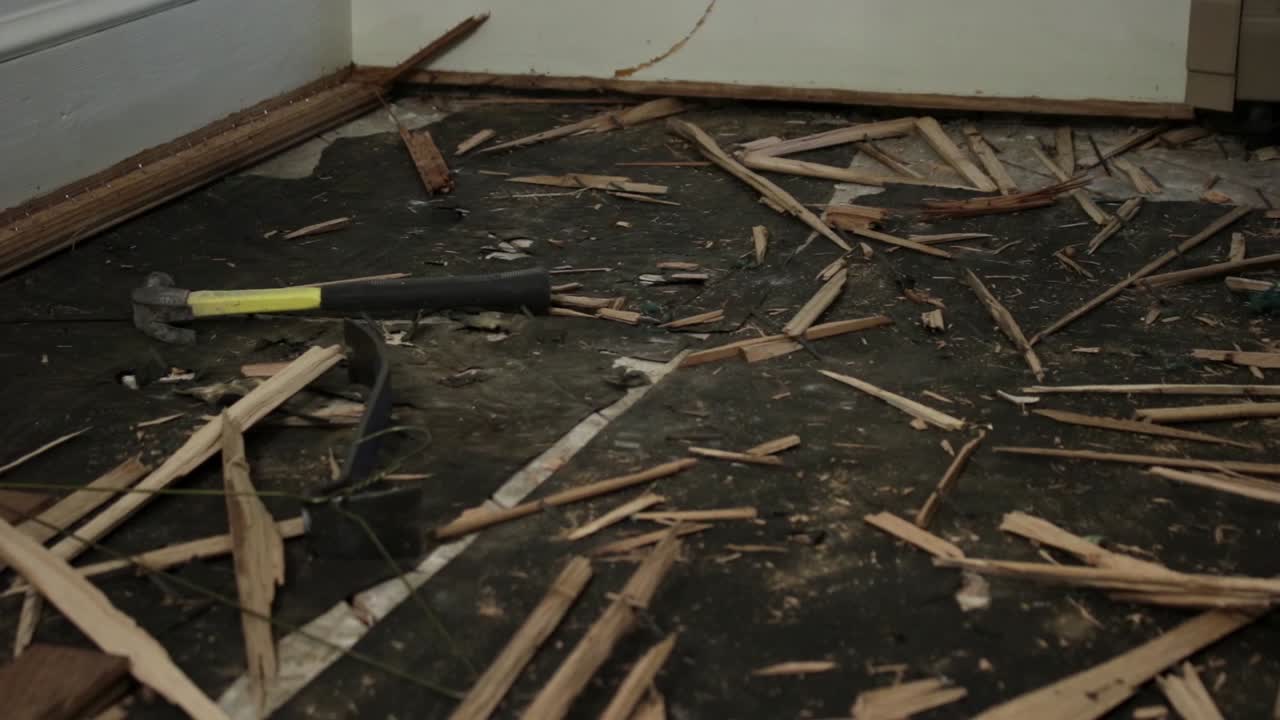 부츠를 입은 청색 목걸이 노동자가 일자리 사이트를 걸어가며 그의 무역의 도구를 집어 들고 있습니다.