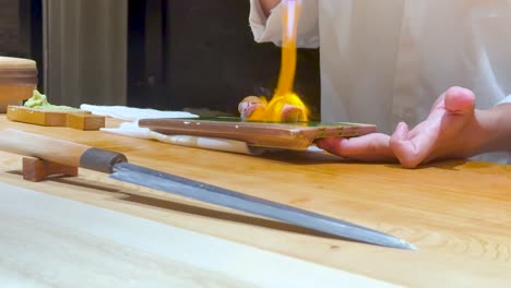 chef flambés sushi with precision and skill