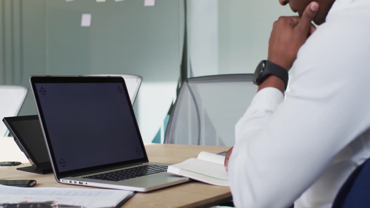 African american businessman using laptop with blank screen in modern office
