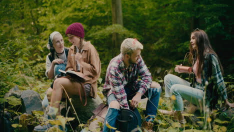 tourists taking rest while sitting on rocks in forest