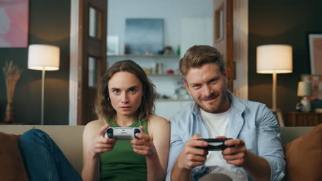 focused friends holding controllers playing game at home pov. couple videogame