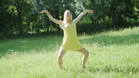 woman in yellow dress dancing gracefully in summer park