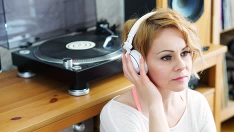 mujer se sienta al lado de la mesa giratoria y escucha música