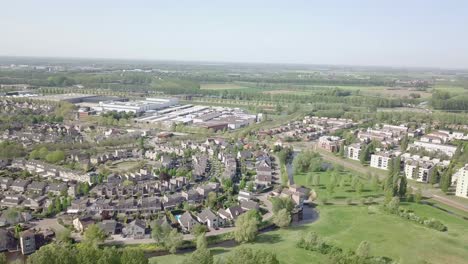 aerial-view-of-the-suburban-houses-and-apartments-near-the-dike-in-Holland-in-4k-24-fps