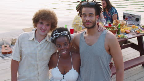 retrato de amigos multiétnicos positivos en la fiesta del lago