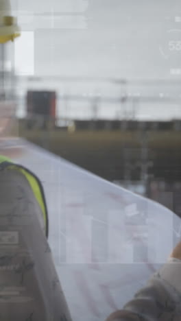 animation of statistics processing over female architect holding plans talking at construction site