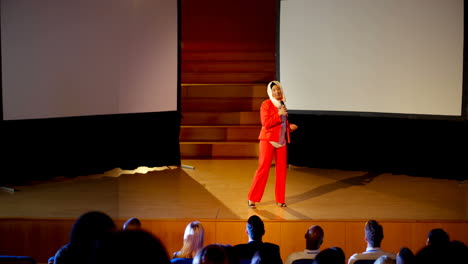 mujer de negocios caucásica madura con hijab hablando en un seminario de negocios en el auditorio 4k