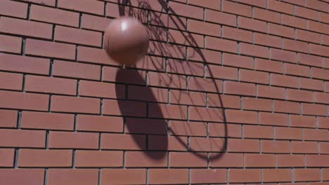 slow motion shot of basketball net silhouette shadow as ball goes into ring scoring goal on red brickwork wall