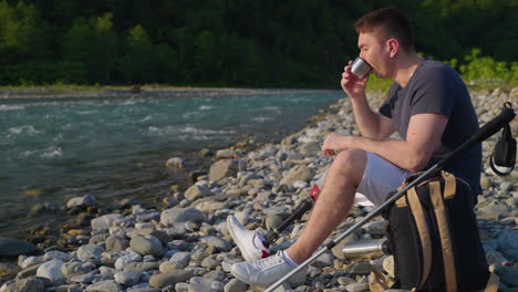 man with prosthetic leg enjoying a coffee break by a river