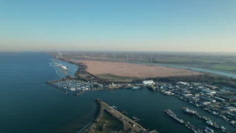 Aerial-View-Of-Boats-Docked-In-The-Marina-With-Scheelhoek-Nature-Preserve-In-Stellendam,-Netherlands