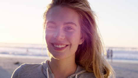 portrait of beautiful girl smiling on beach at sunset in slow motion