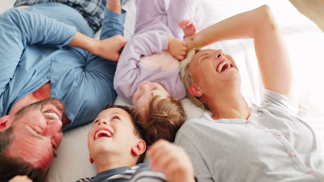 Parents, children and playing on bed in top view