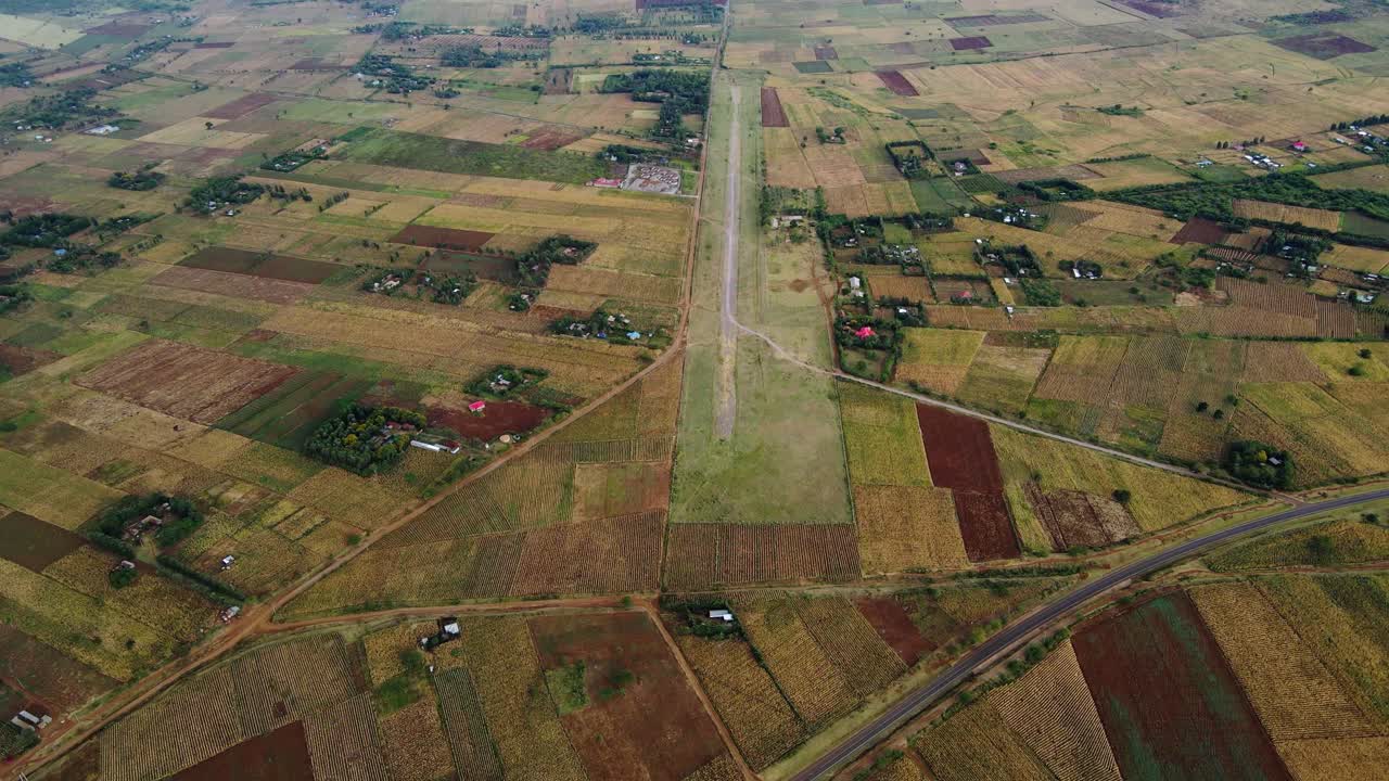 Aerial drone view high above a small aerodome, dark, overcast day, in East Africa