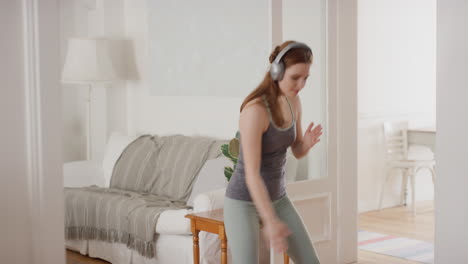 funny woman dancing at home wearing headphones listening to music celebrating with funky dance moves enjoying freedom having fun on weekend 4k