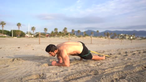 un tipo sin camisa haciendo ejercicios de gateo sobre los codos por la mañana