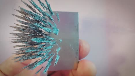 Iron filings moving in the magnetic field of a neodymium magnet, overhead shot