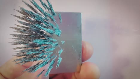 iron filings moving in the magnetic field of a neodymium magnet, overhead shot