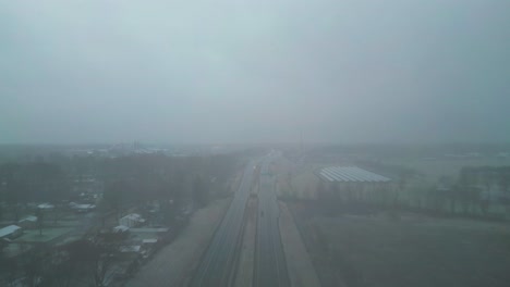 an aerial shot of interstate 80 in the middle of winter with a thick heavy fog surrounding everything