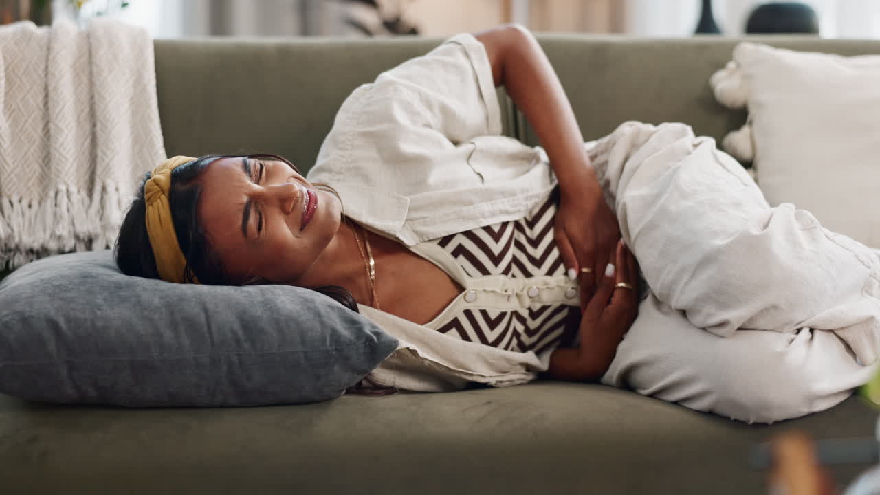 Stomach pain, anxiety and woman on a sofa
