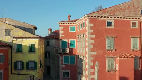 Aerial-dolly-shot-pulling-away-from-buildings-in-the-town-of-Labin,-Croatia-to-reveal-the-landscape-beyond