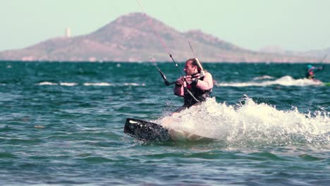 los alcazares, spagna, 3 maggio 2023: sportivo che pratica il kite surf sulla spiaggia in una giornata ventosa sulle coste spagnole