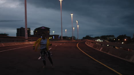 bailarina joven bailarina de calle realizando movimientos modernos de baile hip hop practicando coreografía de estilo libre urbano en la ciudad por la noche