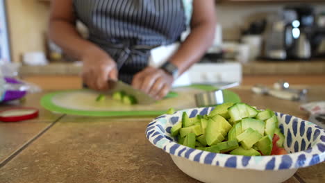 Dicing-cucumber-to-add-to-the-avocado-and-tomatoes-in-making-a-chopped-salad---focus-pull-in-the-ANTIPASTO-SALAD-SERIES