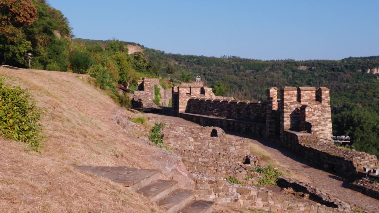 Sentiero storico in pietra all'interno della Fortezza di Tsarevets a Veliko Tarnovo, Bulgaria, circondato da mura medievali e vegetazione naturale