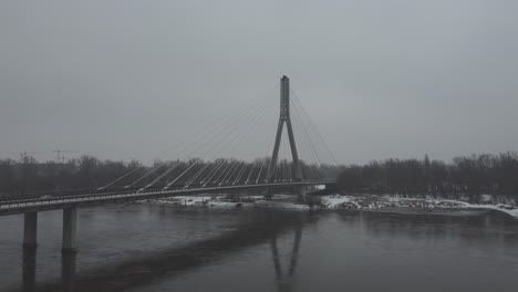 drone video of and swietokrzsyki bridge, warsaw  above vistula river on a  snowy day -1