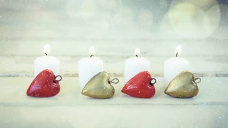 velas y decoración navideña combinadas con la nieve que cae