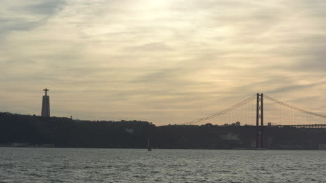 lapso de tiempo del santuario de cristo rey con tráfico rodado en el puente 25 de abril y el río tejo