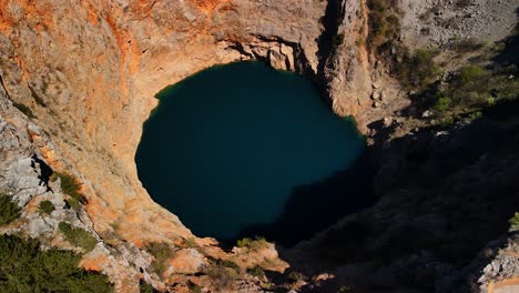 una toma de drones del lago rojo o crveno jezero, que es un sumidero colapsado que contiene un lago kárstico cerca de imotski, croacia