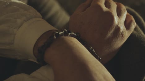las manos atadas de un prisionero arrestado por un delito