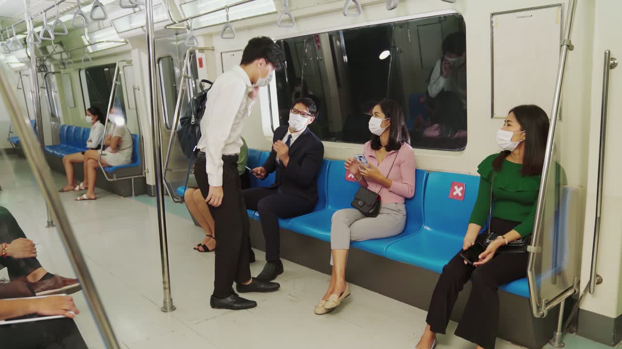 여성은 사회적 거리를 지키기 위해 열차에서 남자가 에 앉지 못하게합니다.