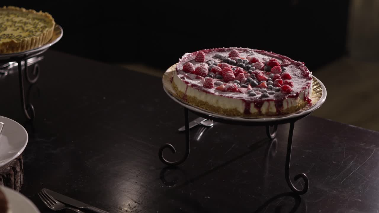 Delicious berry cheesecake with raspberries and blueberries on a black table