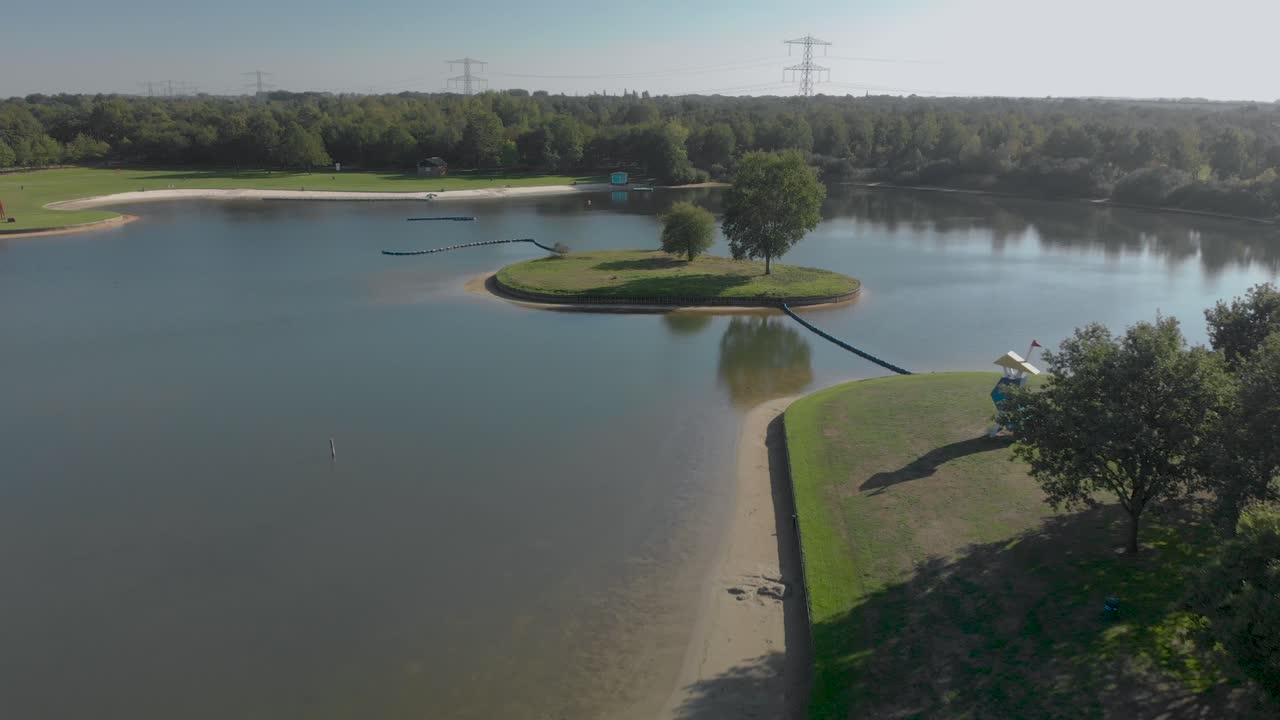 Aerial view of an almost empty artificial recreational lake in The Netherlands backing up revealing the wider surrounding of the island
