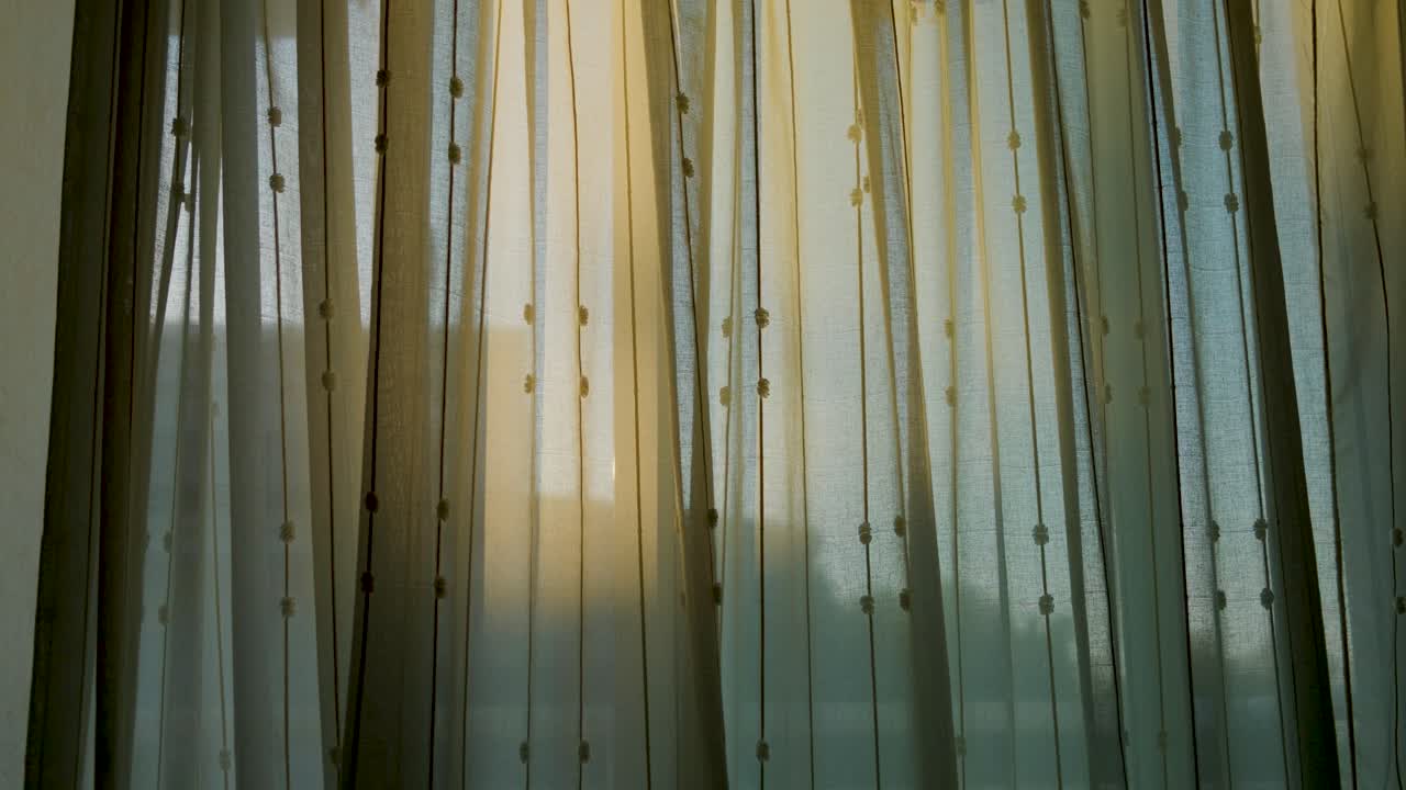Soft sunlight streams through delicate sheer curtains creating a peaceful and cozy ambiance