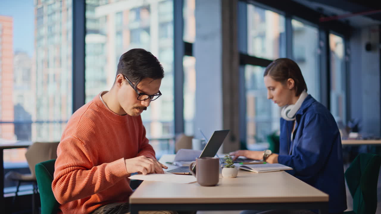 Two managers analyzing financial statements in open space. Colleagues working