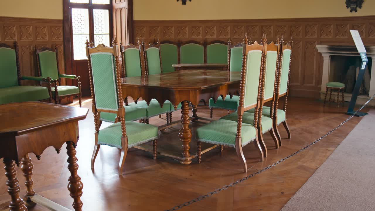 elegante conjunto de comedor de madera con tapicería verde en la sala de caza del castillo de trakošćan