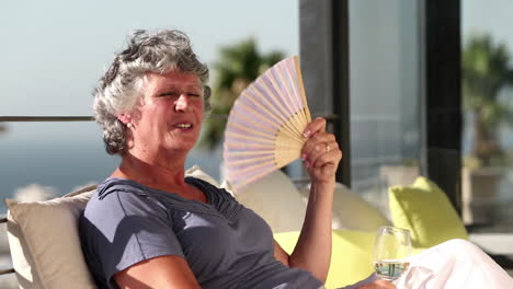 woman fanning herself on the balcony