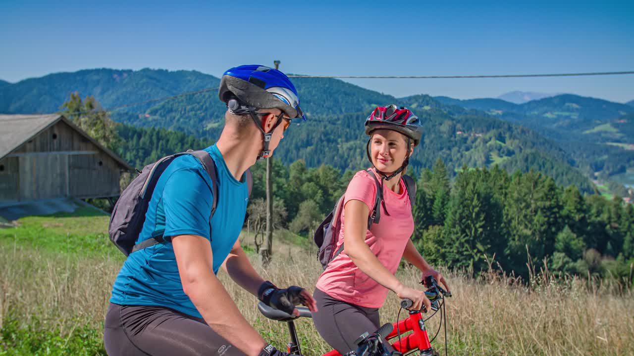 Young couple of cyclists start pedaling after stopping, Slovenia
