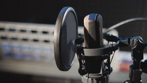 estudio de grabación de audio con micrófono de primer plano. micrófono contemporáneo con filtro en soporte en una habitación acústicamente aislada. equipo de grabación