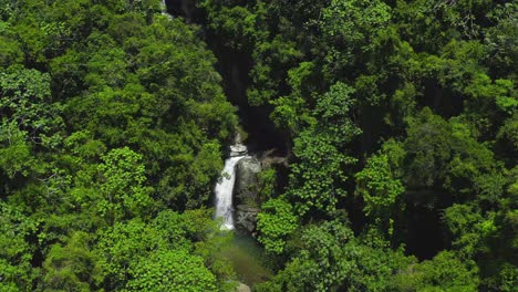 El-Agua-Se-Estrella-Sobre-Un-Pequeño-Acantilado-Rodeado-De-Hermosos-árboles-Y-Arbustos-Verdes-Y-Exuberantes,-Cascada-De-Saltos-Jima,-Drones-Aéreos