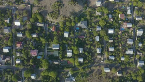 La-Maravillosa-Vista-De-Pájaro-De-Un-Pueblo-En-Georgia-En-El-Fondo-Con-árboles,-Casas-Y-Vistas-A-La-Montaña---Toma-Aérea