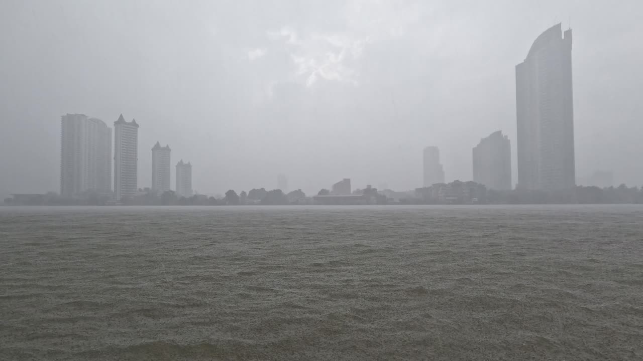 태국 방의 차오프라야 강 (chao phraya river) 에서 강한 비가 내리고 높은 건물의 실루이 배경에 있습니다.