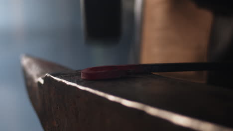 forging a metal rod with a hammer on an anvil in a metal workers workshop